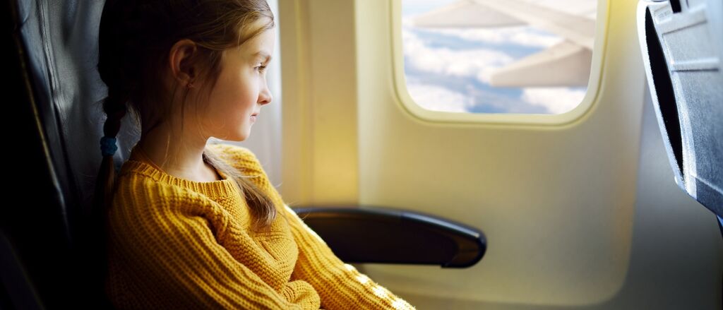 Child looking at aircraft wing from inside the aircraftshutterstock 397982302
